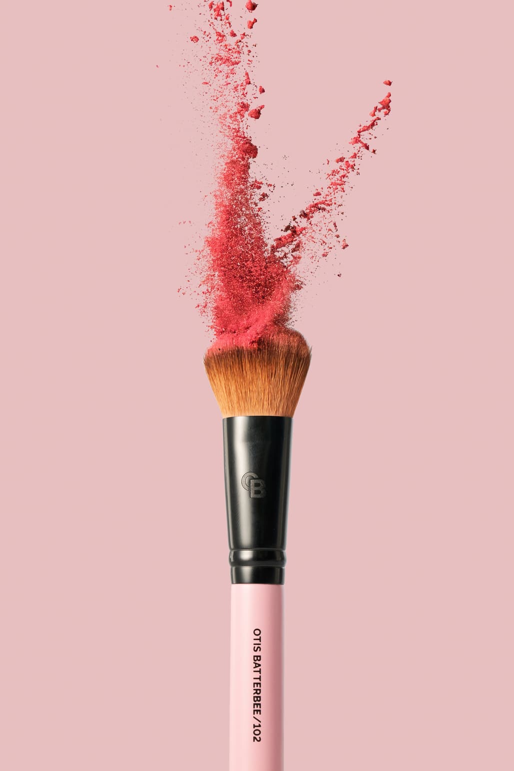 Makeup brush with pink powder splashes on a pink background