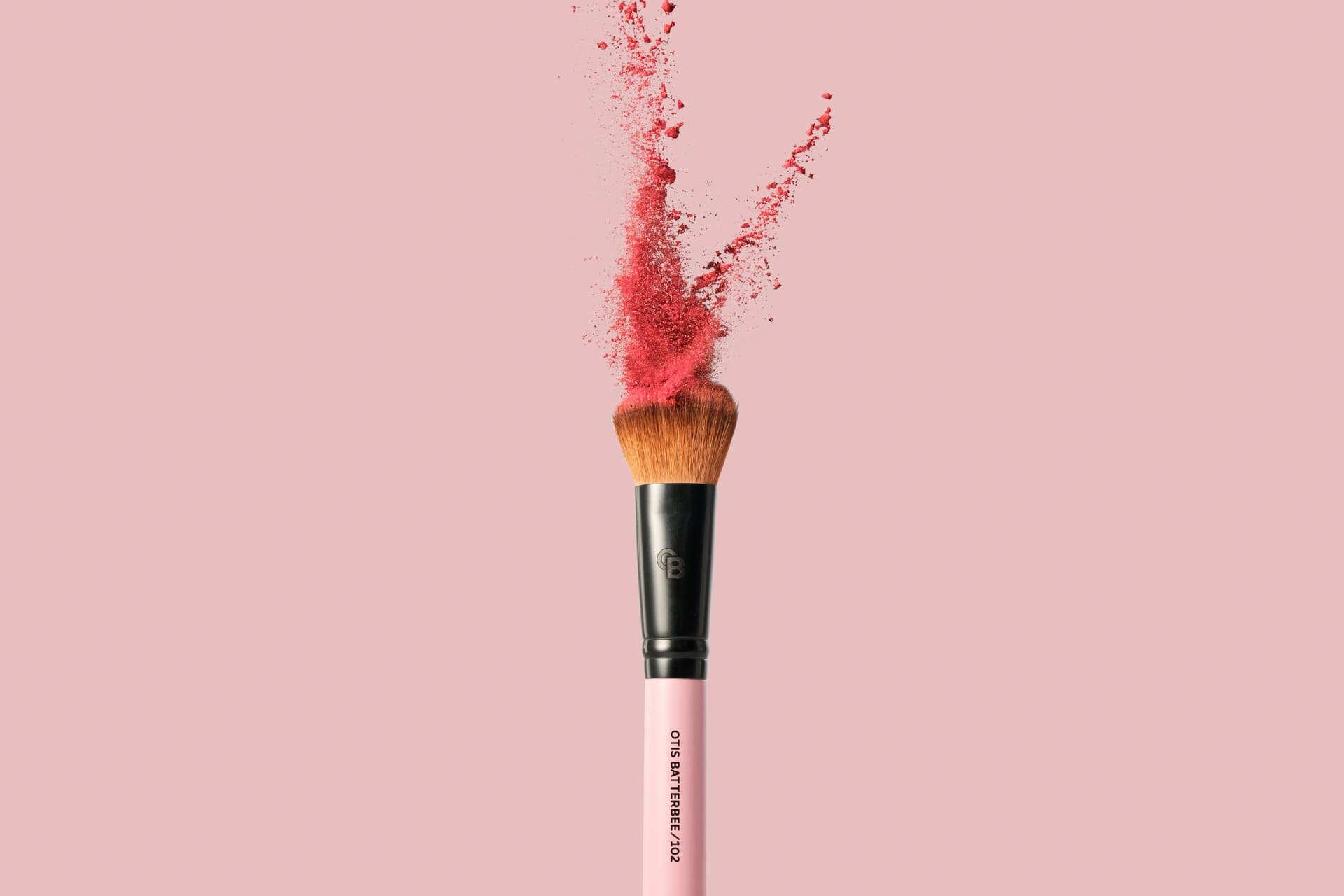 Makeup brush with pink powder on a pink background