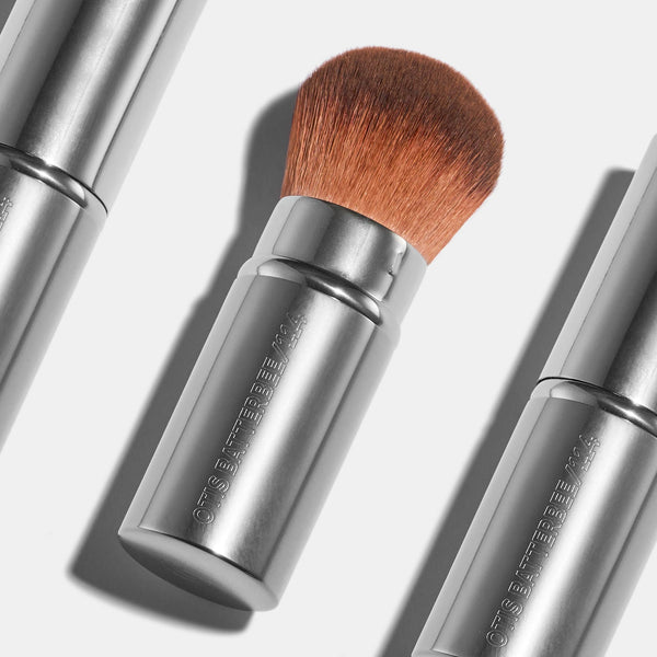 The Otis Batterbee retractable travel kabuki powder brush in silver metal. The perfect travel and handbag sized bronzer and blusher brush. 